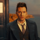 Standing outside his TARDIS, the Tenth Doctor looks alarmed and confused.